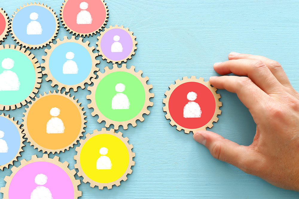 image of cog wheels puzzle blocks with people icons over wooden table ,human resources and management concept image of cog wheels puzzle blocks with people icons over wooden table ,human resources and management concept